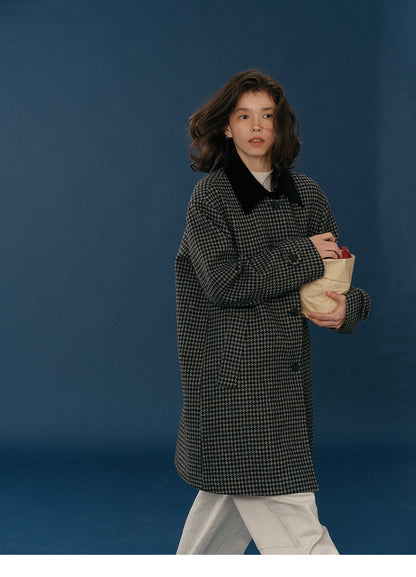 Side walking view showing the coat’s midnight houndstooth pattern and relaxed silhouette.