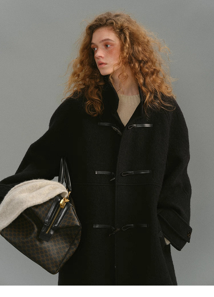 Black alpaca-wool toggle coat front view with brushed texture.