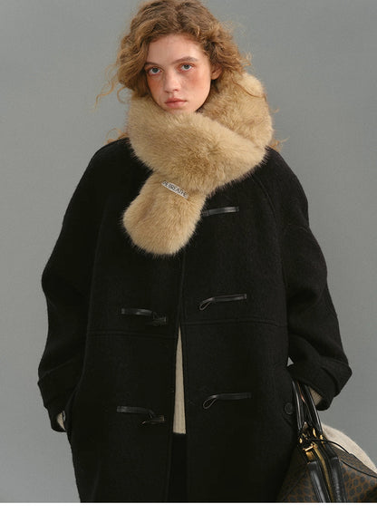 Black toggle coat styled with a beige fur scarf on the model.