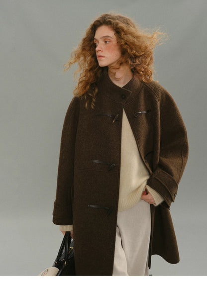Close-up of brown wool toggle coat highlighting toggle details and texture.