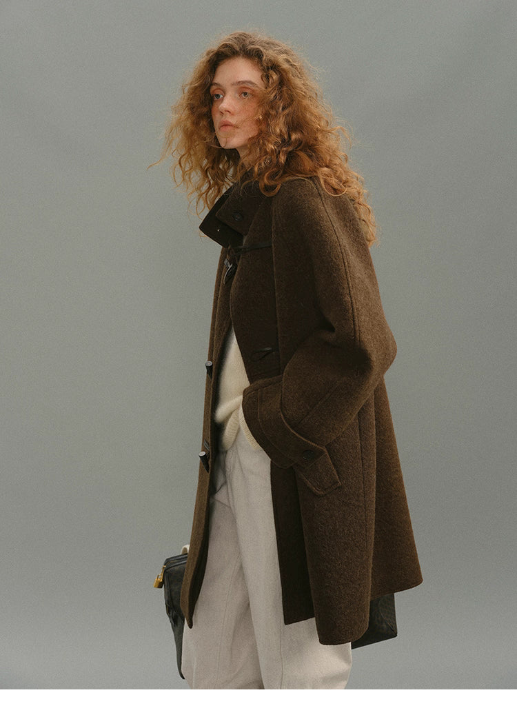 Side angle of brown toggle coat showing relaxed silhouette and collar.