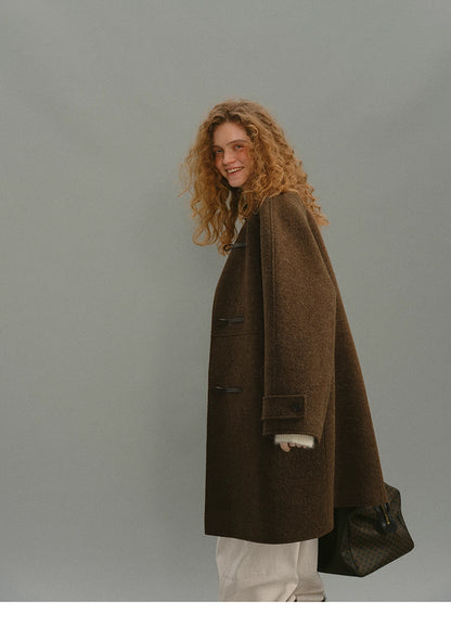 Model walking in brown toggle coat showing mid-length drape.
