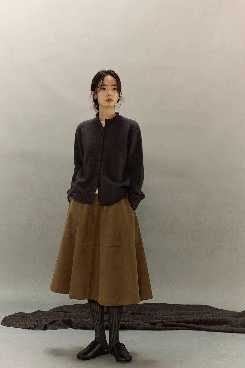 Woman in charcoal yak wool cardigan styled with brown midi skirt, tights and black flats, full front view
