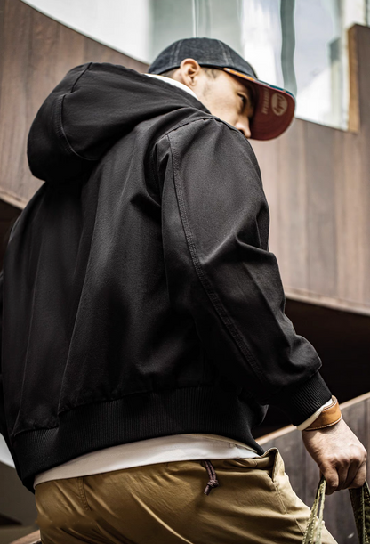 Back view of Black Adventure Ready Hooded Jacket worn by model showing hood structure, relaxed fit and ribbed hem finish