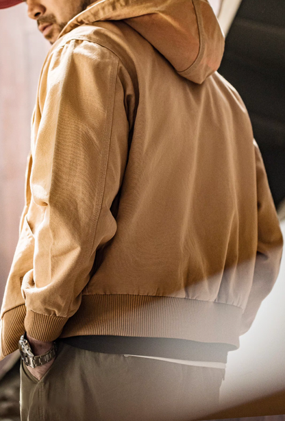 Back view of Khaki Adventure Ready Hooded Jacket worn by model highlighting hood shape, smooth fabric and ribbed waistband