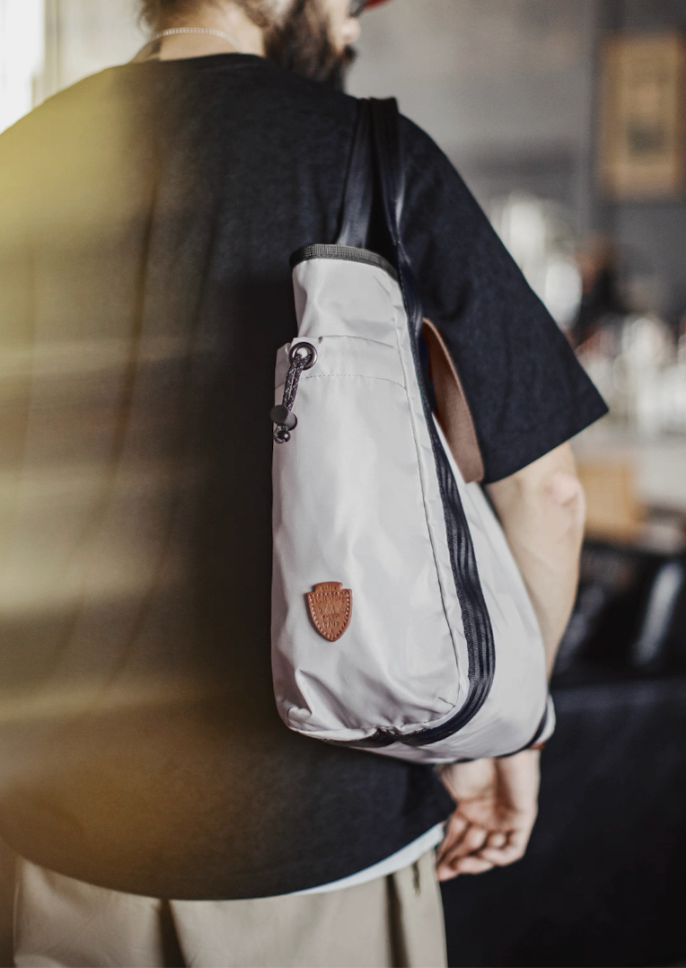 Side profile of All-Weather Outdoor Tote Bag showing drawstring pocket and logo patch