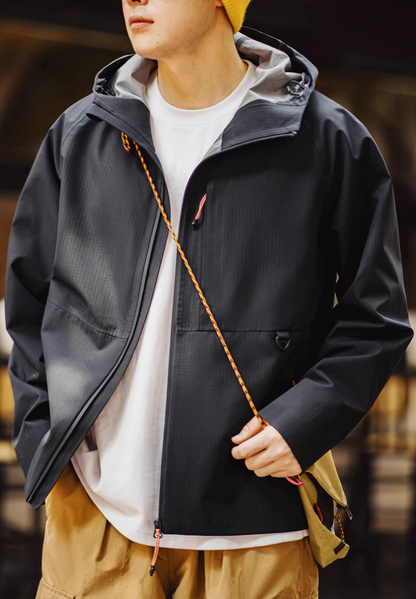 Black ripstop shell coat with adjustable hood worn casually showing lightweight design and streetwear styling