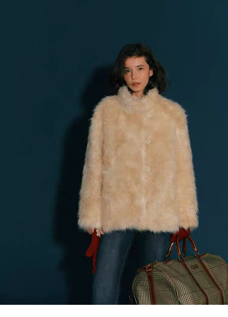 Full-body shot of model wearing Almond Aura Plush Coat against dark blue background