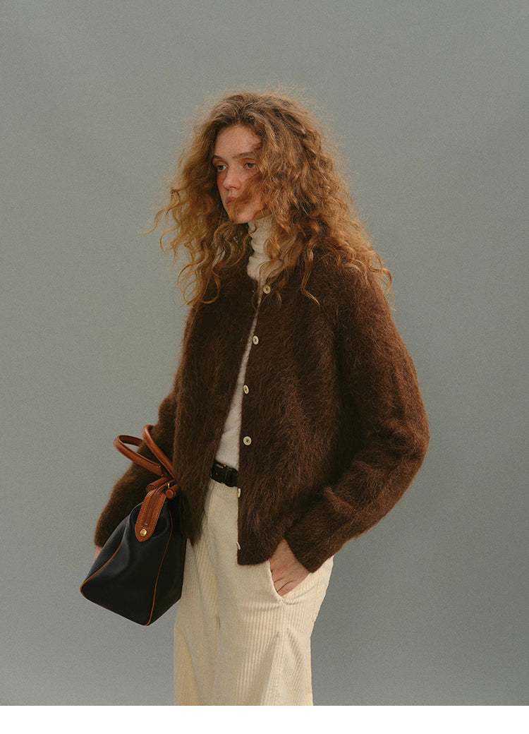 Model standing in Deep Caramel Brown alpaca cardigan with turtleneck and cream trousers