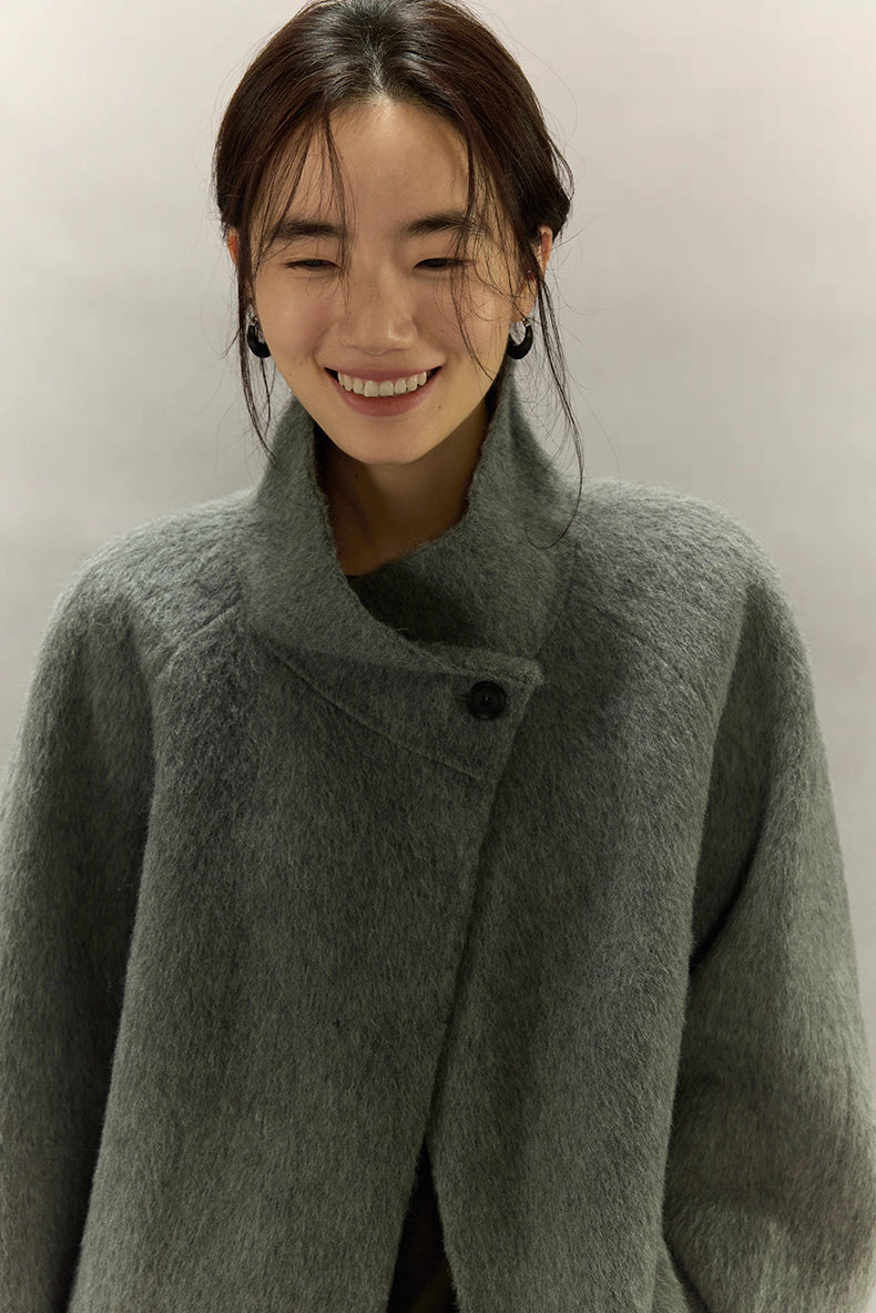 Close-up of sage gray alpaca jacket showing soft sculpted stand collar and texture