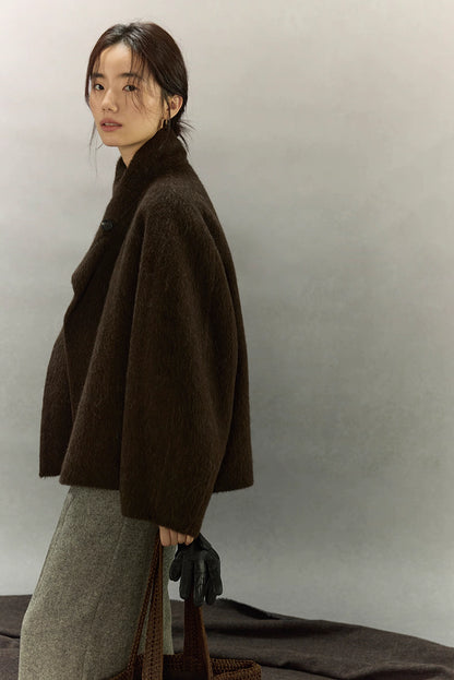 Side profile of dark coffee brown alpaca jacket with relaxed sleeves and collar