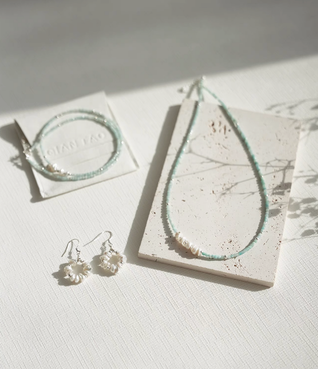 Amazonite and Baroque pearl choker displayed with matching bracelet and earrings jewelry set flat lay