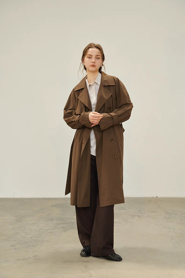 Dark brown belted trench coat full front view with relaxed fit and double breasted button closure
