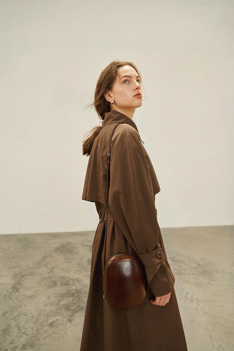 Dark brown short trench coat side view with belted waist and compact silhouette