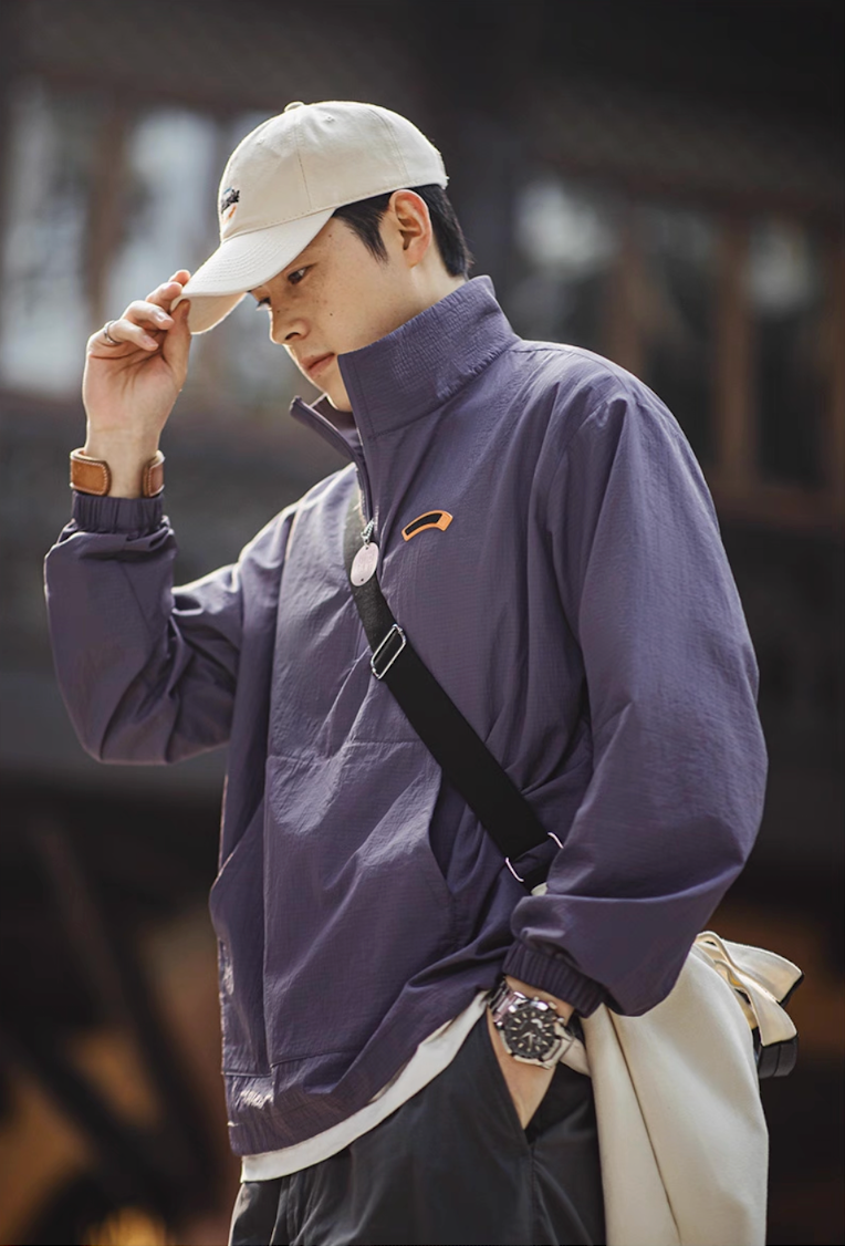 Street style look with dusty purple anorak jacket paired with crossbody bag and cap