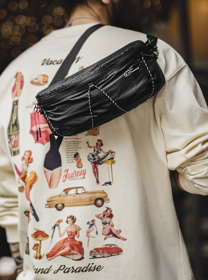 Model wearing black AON sling bag crossbody with graphic tee