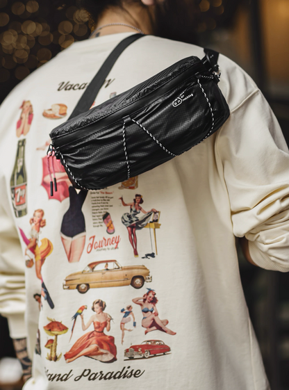 Model wearing black AON sling bag crossbody with graphic tee