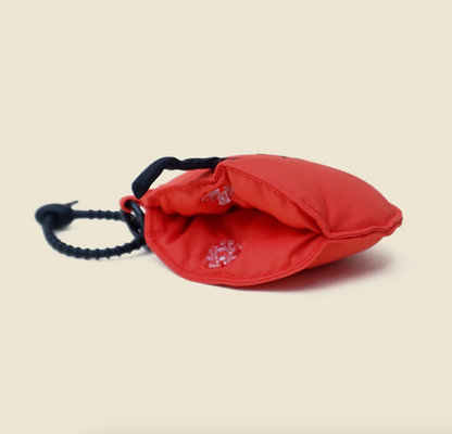 Side view of red apple face zip pouch keychain with open pocket.