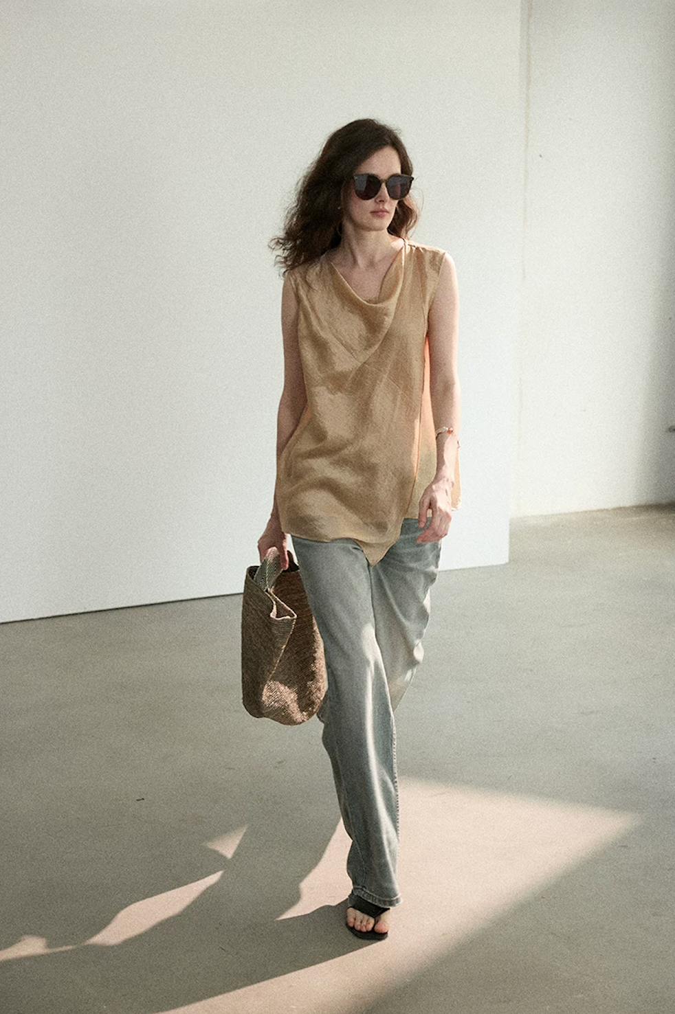 Front view of model walking in Apricot top with asymmetric pointed hem