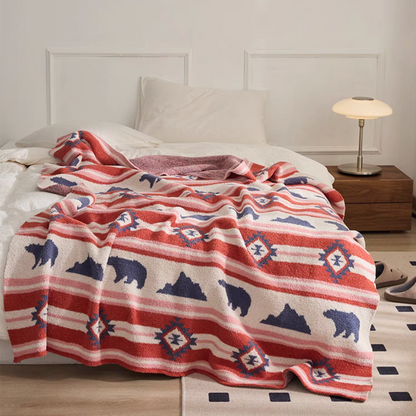 Red Embroidered Bear throw blanket laid across bed featuring bold red stripes with bear and diamond motifs