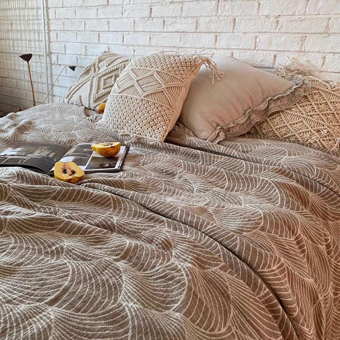 ArcWeave linen cotton handloom throw blanket in coffee color draped across bed with woven arc pattern and neutral boho pillows