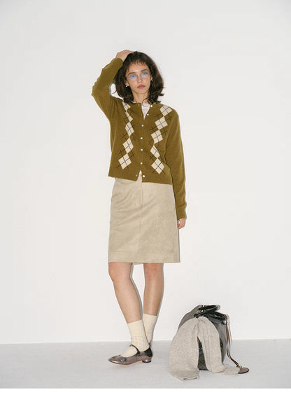 model wearing olive green argyle wool cardigan full body standing pose