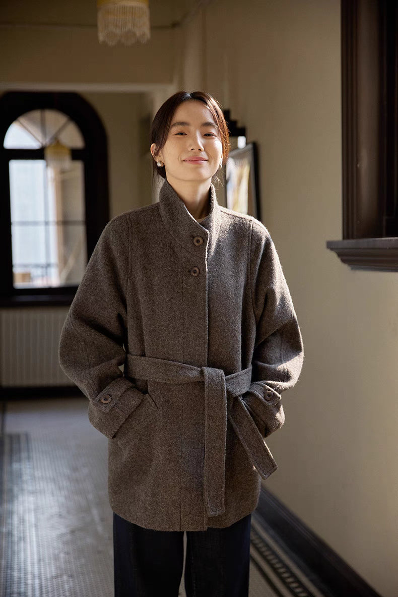 Gray wool belted jacket front view with stand collar, button closure and relaxed tailored fit