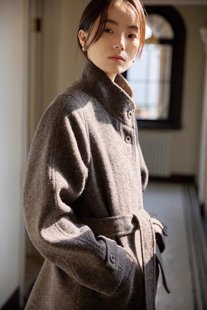 Gray wool jacket side angle in natural light emphasizing texture, collar and waist belt