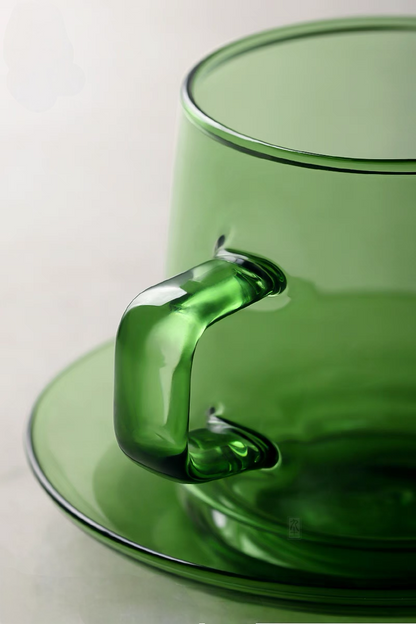 Close-up of green Aurora Harmony glass cup handle and saucer showing smooth borosilicate glass craftsmanship