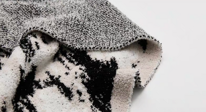 Detailed view of blanket corner revealing contrast between patterned front and gray-toned reverse backing