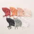 Multiple baby linen cotton sun hats in assorted colors arranged flat lay showing full collection