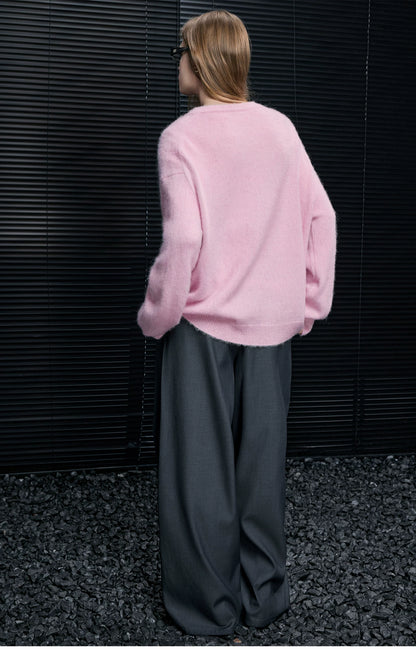 Back view of Baby Pink oversized Henley sweater showing dropped shoulders, styled with grey wide-leg trousers