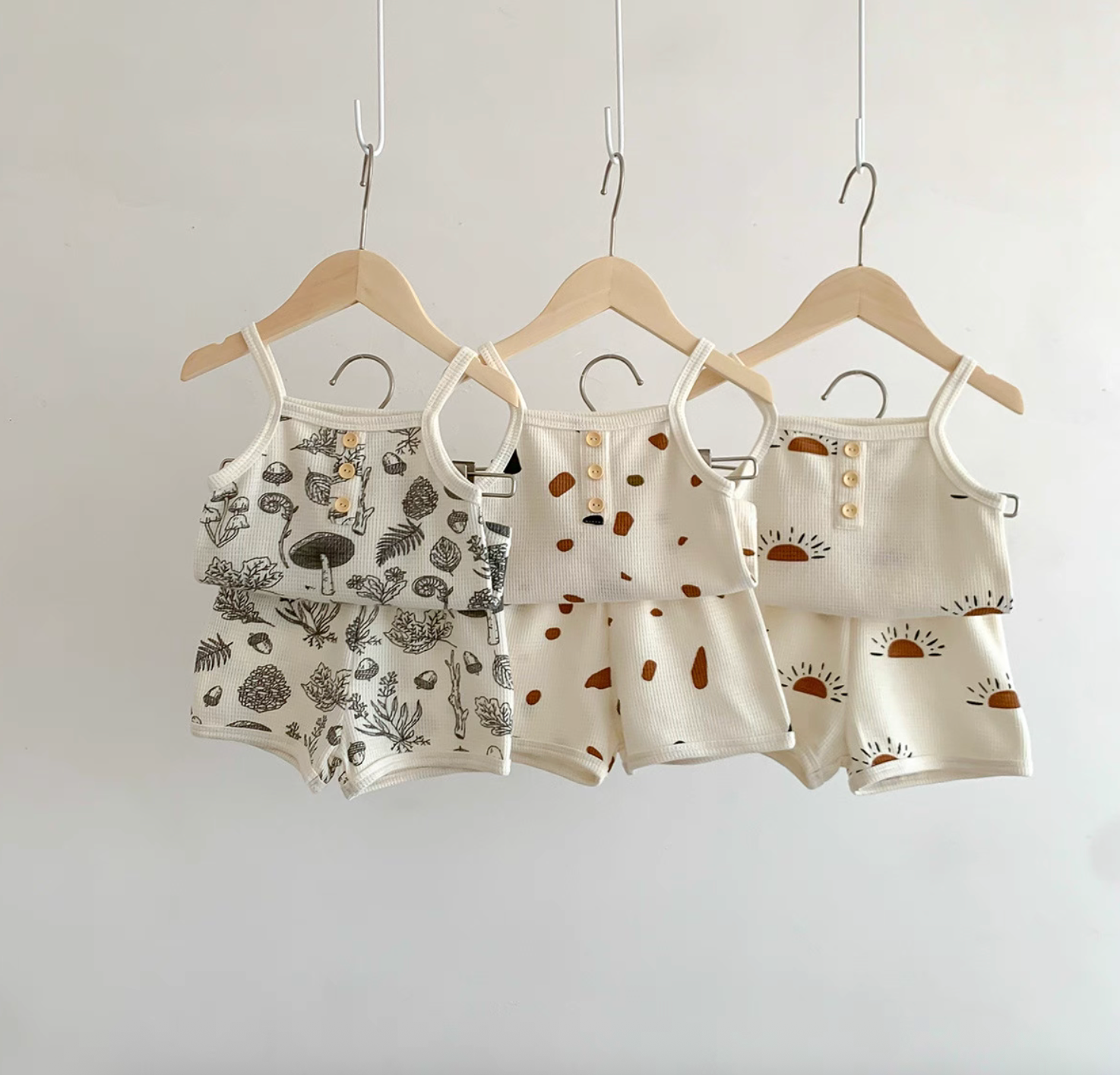 Baby waffle knit tank and shorts sets in three prints hanging on hangers