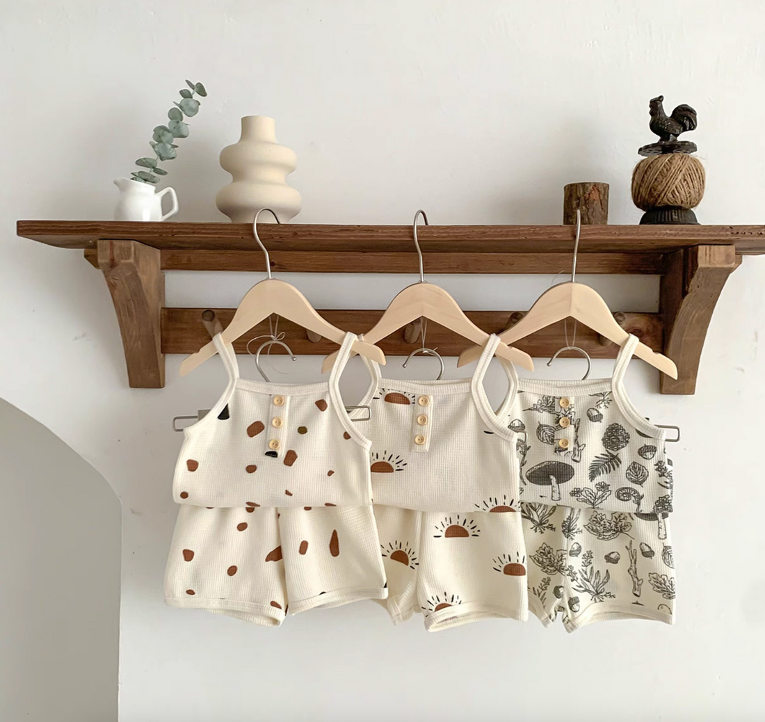 Baby waffle knit tank and shorts sets hanging under wooden shelf with decor
