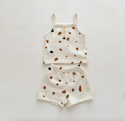 Flat lay of baby waffle knit set with colorful stone print tank and shorts