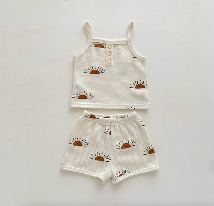 Flat lay of baby waffle knit set with sunshine sunrise print top and shorts