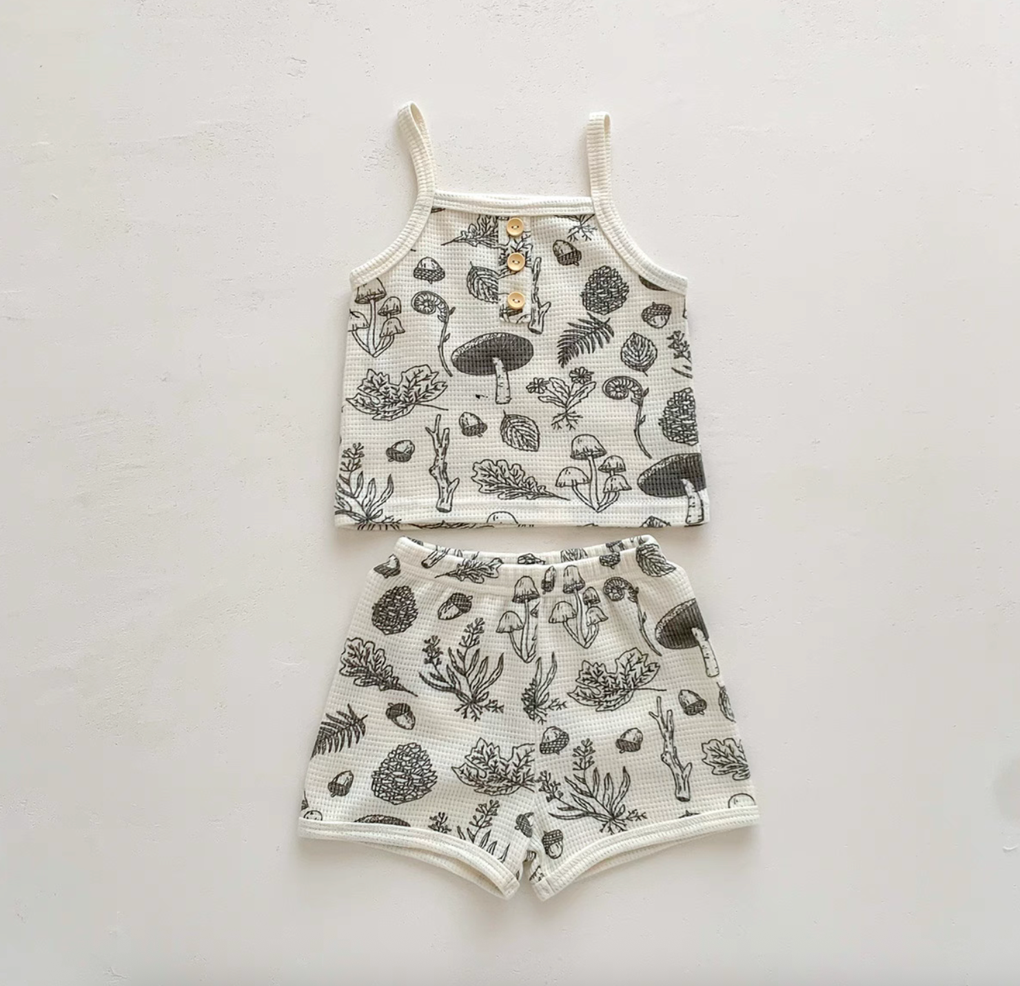 Baby waffle knit set in woodland sketch print laid flat on white background