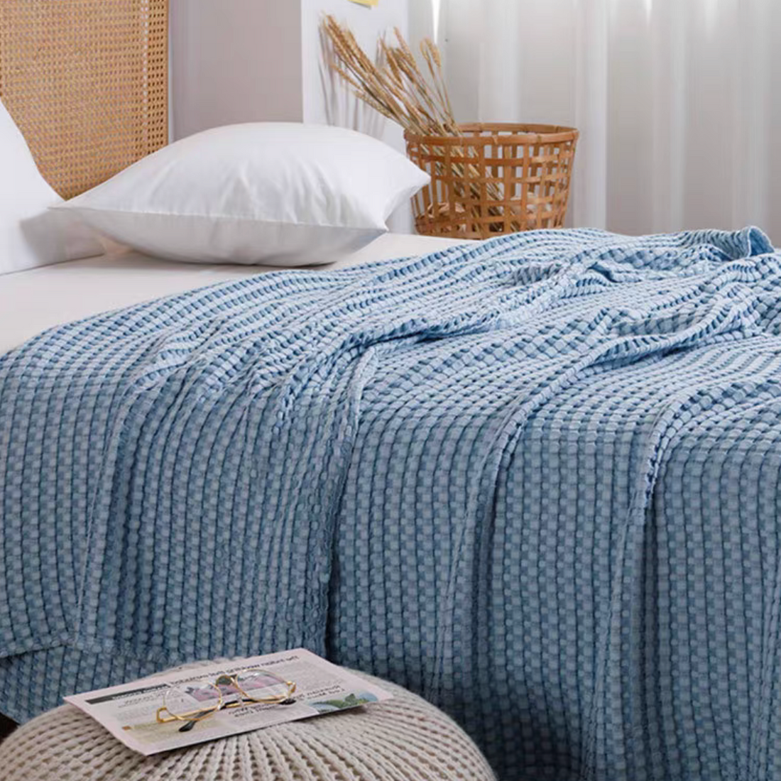 Blue bamboo fiber cotton waffle throw blanket draped across bed, breathable lightweight sofa throw with textured waffle knit design