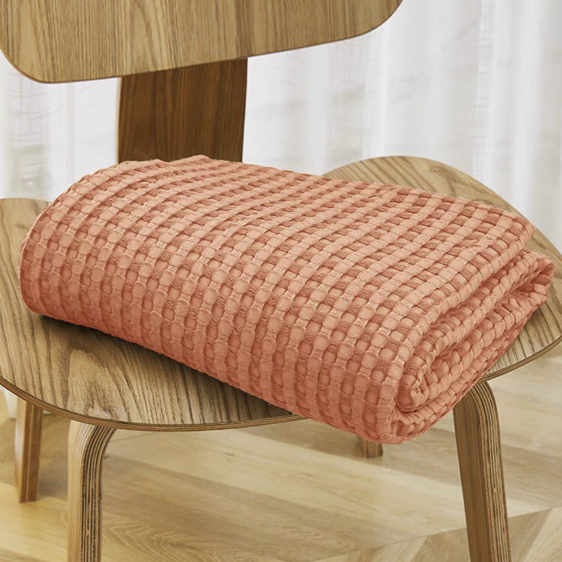 Orange bamboo fiber cotton waffle throw blanket folded on chair showing soft textured knit breathable sofa throw design