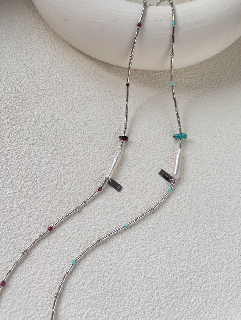 Baroque Elegance Layered Necklace featuring turquoise and garnet accents with baroque pearl and silver chain displayed together