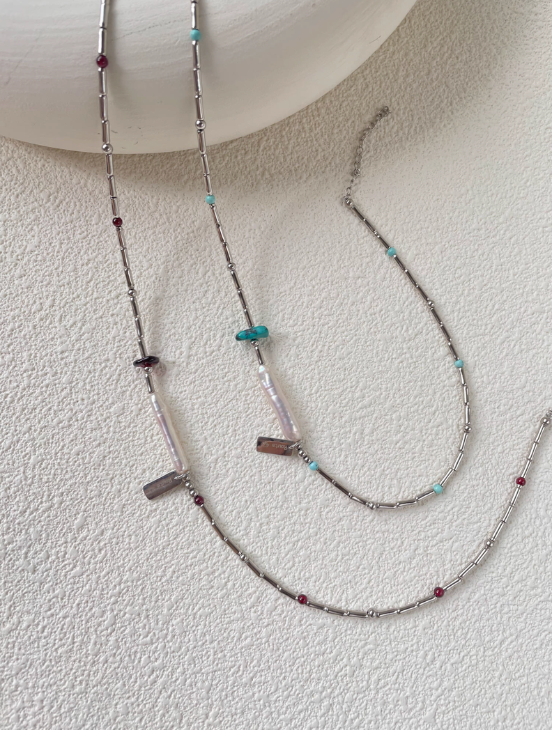 Full length view of Baroque Elegance Layered Necklace with turquoise and garnet details, baroque pearl centerpiece and silver chain