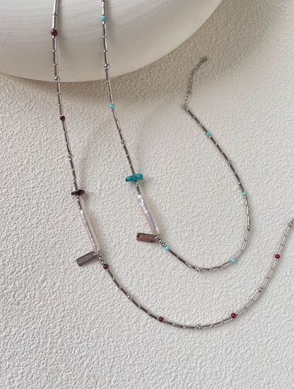 Full length view of Baroque Elegance Layered Necklace with turquoise and garnet details, baroque pearl centerpiece and silver chain