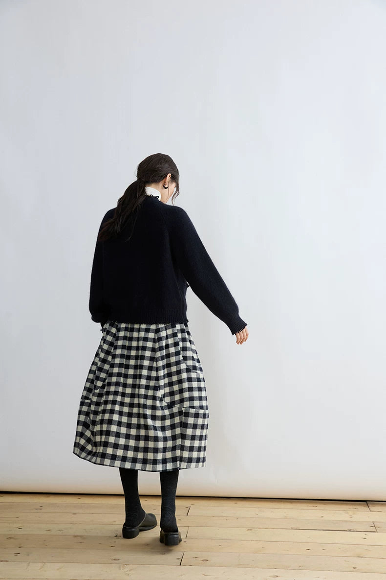 Back view of a black and cream gingham balloon skirt falling to mid-calf