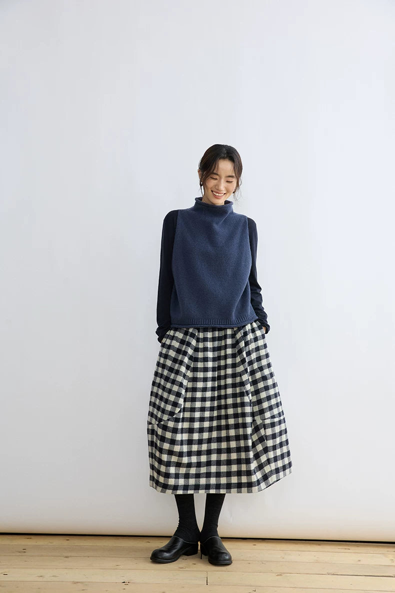 Model wearing a black and cream gingham wool balloon midi skirt, front view