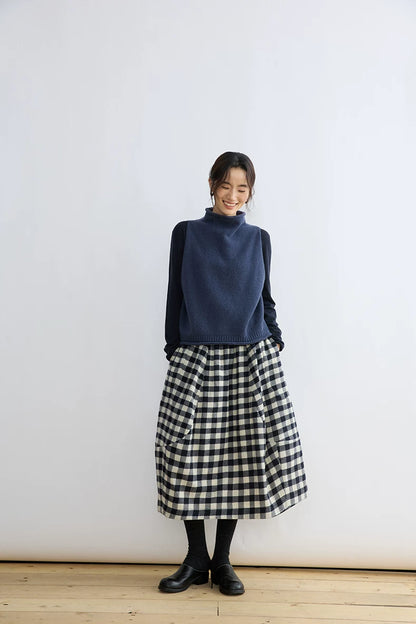 Model wearing a black and cream gingham wool balloon midi skirt, front view