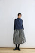 Model wearing a black and cream gingham wool balloon midi skirt, front view