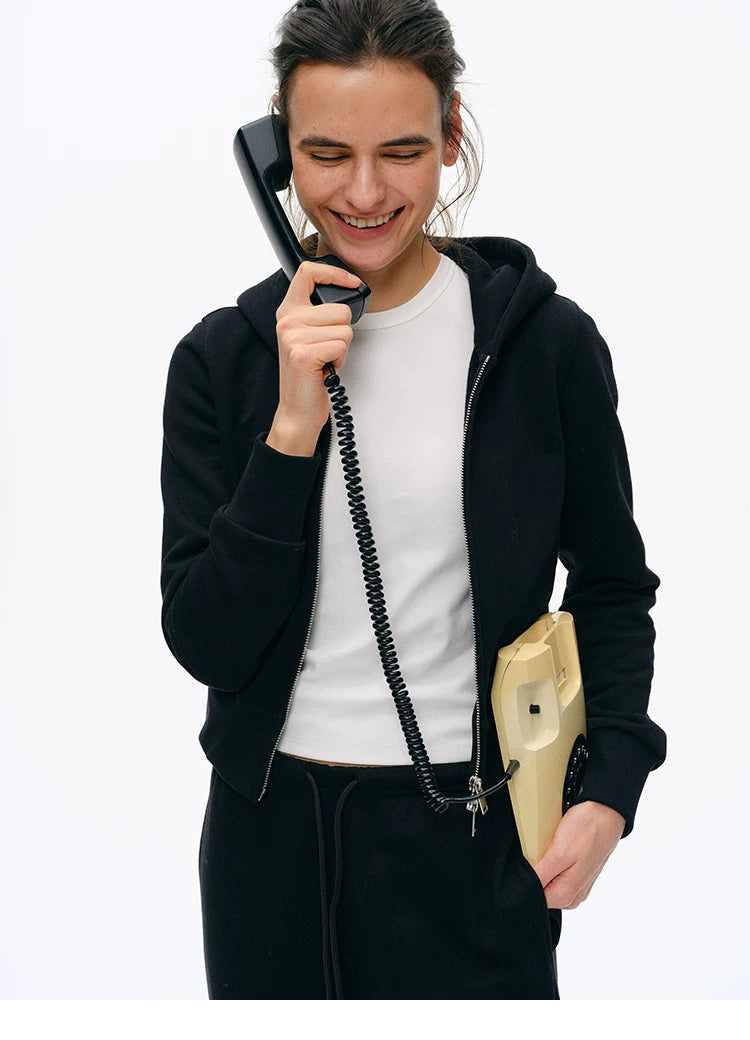 Smiling model in Black cotton zip hoodie worn open, front view