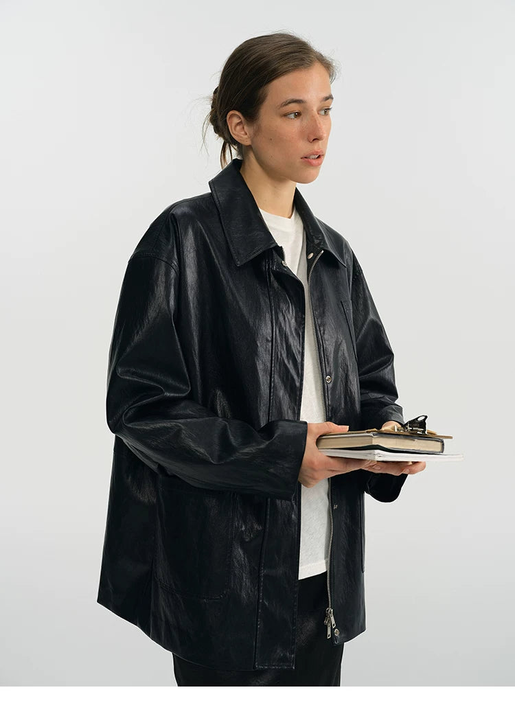 Black faux leather jacket with point collar and zip front, three-quarter side view
