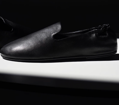Side profile of a Black slipper loafer with low-cut vamp and scrunched back