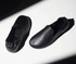 Pair of Black lambskin slipper loafers with gathered elastic heels, angled view in dramatic light